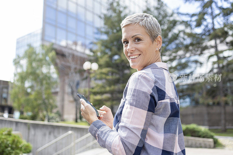 微笑的女人过马路时发短信