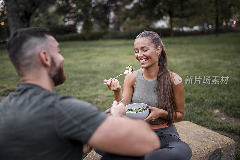 一对快乐的情侣在高强度锻炼后吃蔬菜沙拉
