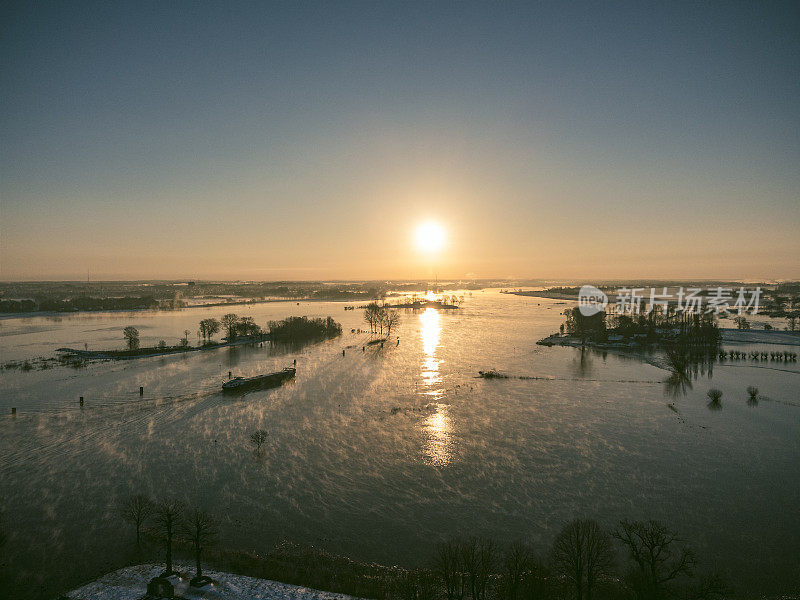 在一个雾蒙蒙寒冷的冬日早晨，IJssel河上的日出