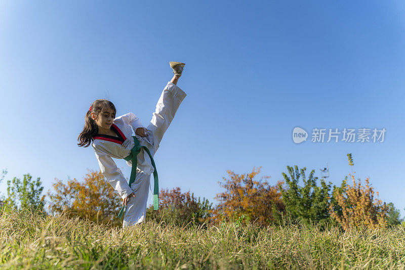 在公园草地上练习跆拳道的女孩