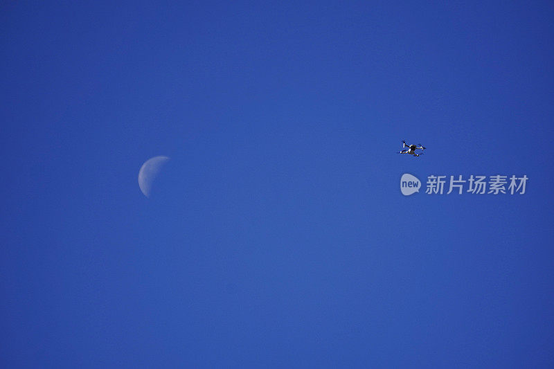 低角度拍摄的mavic无人机和月亮在蓝天