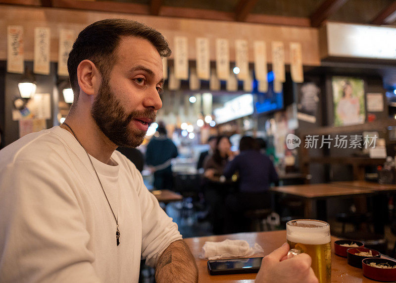 外国游客在日本居酒屋酒吧喝啤酒