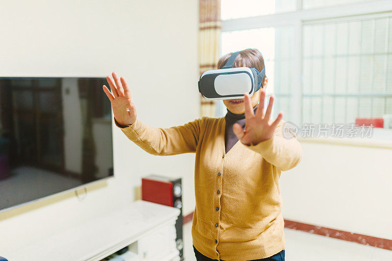 一位中年妇女沉浸在VR眼镜中——科技与生活，健康的生活方式