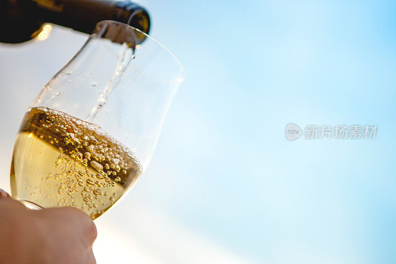 把香槟酒倒进玻璃杯里