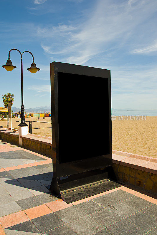 沙滩上一个空的黑色广告牌的垂直镜头