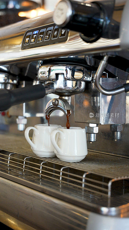 浓缩咖啡从咖啡机的两侧优雅地倒出的特写镜头。