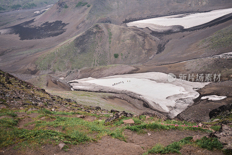 一群游客接近火山挤压骆驼