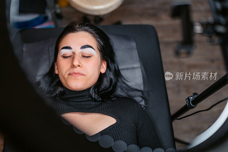 美容院的一位女顾客在用微刮刀剃完眉毛后躺在椅子上