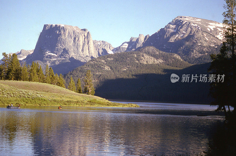 在绿色的河流湖和渔民与方顶山在怀俄明州风河山脉的背景