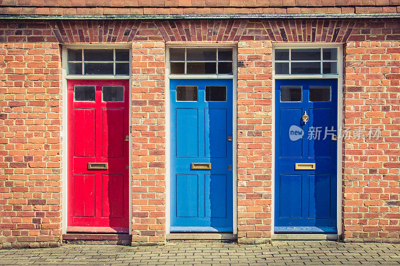 古老的英国排屋的入口处有三扇不同颜色的前门。英国的坎特伯雷。