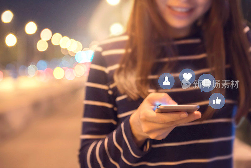 在大街上，一个女人用智能手机摆弄着社交媒体和社交网络图标。
