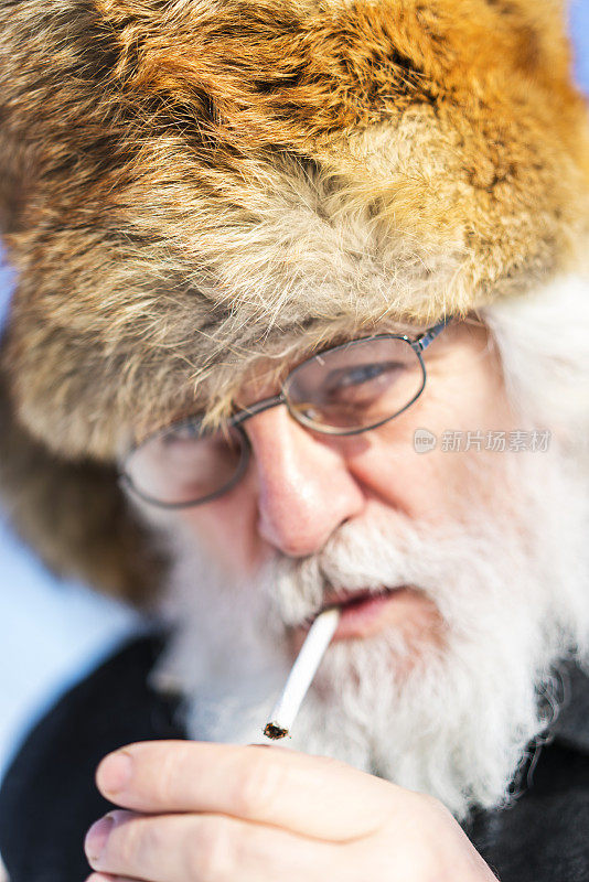 白胡子老人的画像，他正点燃一支香烟