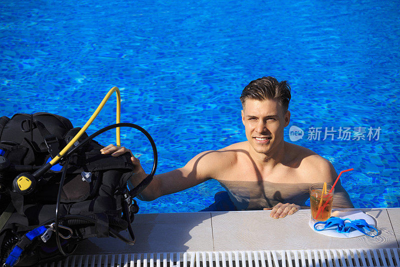 水肺潜水课程一个年轻人在游泳池里用潜水设备看着照相机