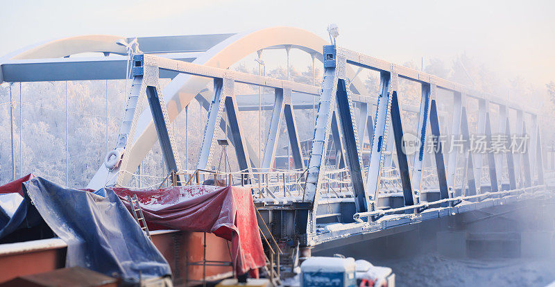 桥梁施工现场，在一个寒冷的冬天，过了河，桥梁正在施工中