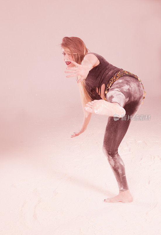 在土耳其伊斯坦布尔的工作室里，一名年轻女子在灰尘和粉末中跳舞