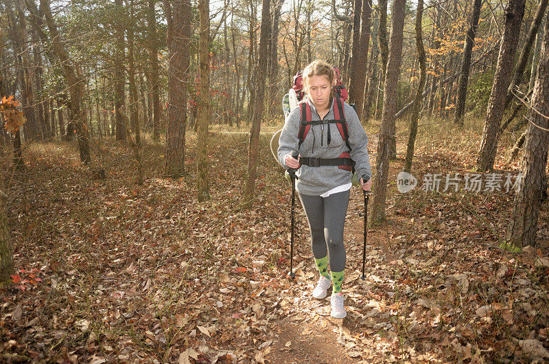 一个在树林里背包旅行的年轻女子