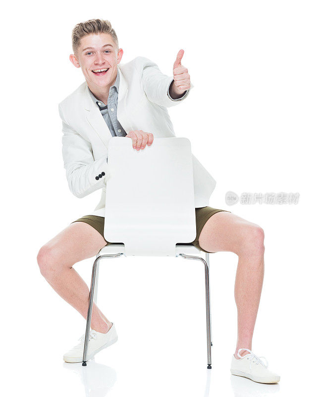 英俊的年轻人向后坐在椅子上，竖起大拇指