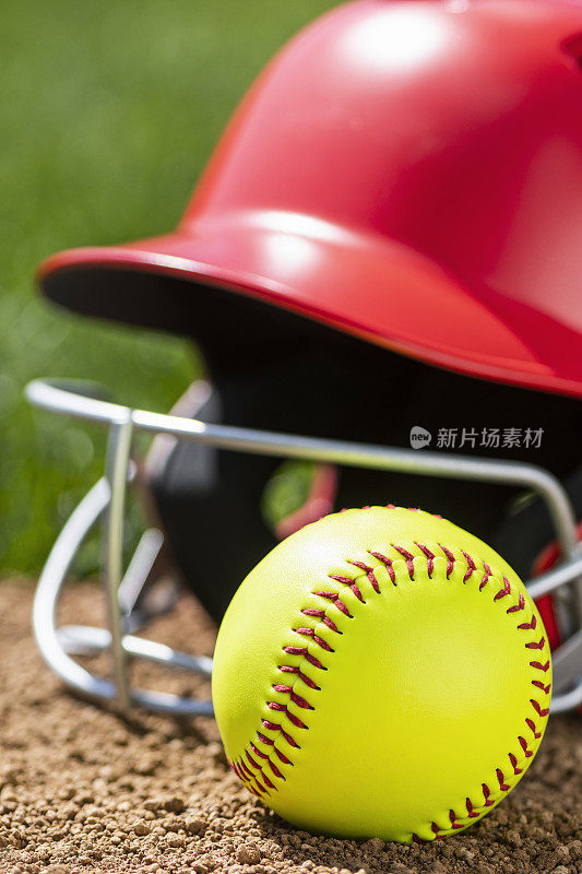 一个黄色的垒球，戴着红色的棒球帽