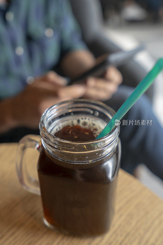 一个年轻人在咖啡店里冰咖啡杯的照片