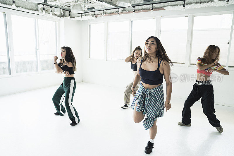 年轻的女舞者在舞蹈工作室跳舞。