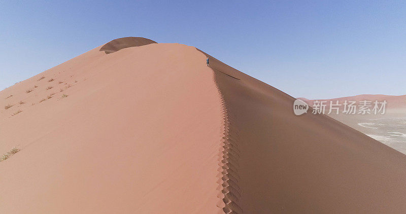 一个人在爬一个巨大的沙丘。鸟瞰图