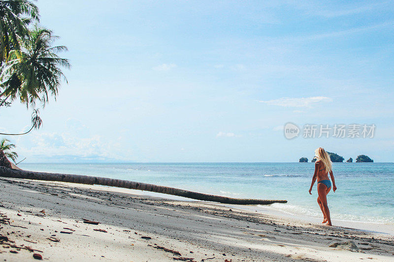 在热带海滩上漫步的女孩