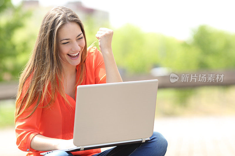 心情愉悦的女人在公园里用笔记本电脑找工作