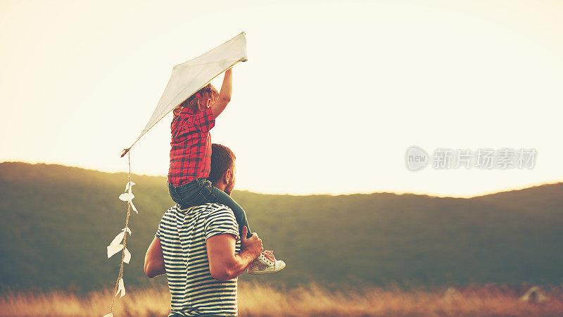 幸福的家庭，父亲和孩子在草地上放着风筝