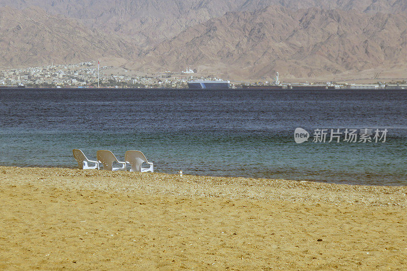 以色列埃拉特海滩上的三张空椅子