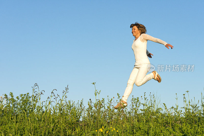 快乐的女人在草地上奔跑