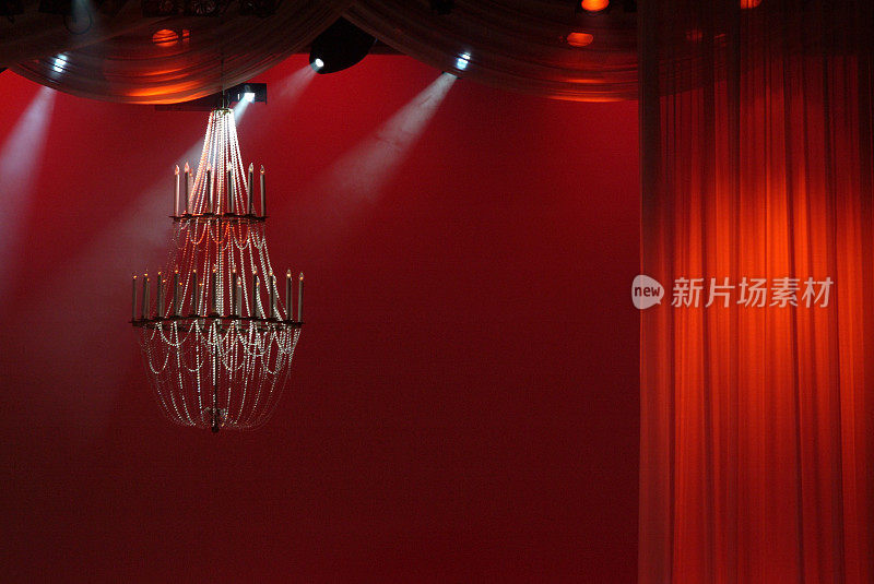 舞台背景与深红色的窗帘和吊灯
