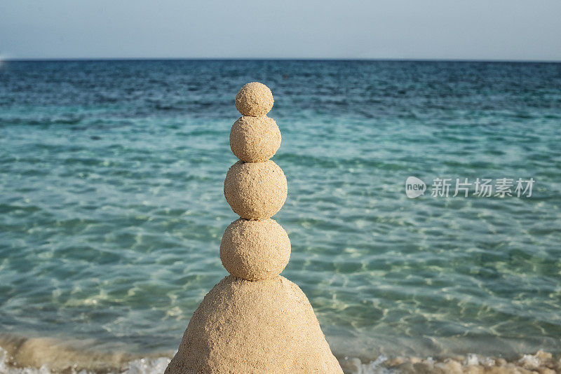 沙滩沙雕用四个堆叠的沙球