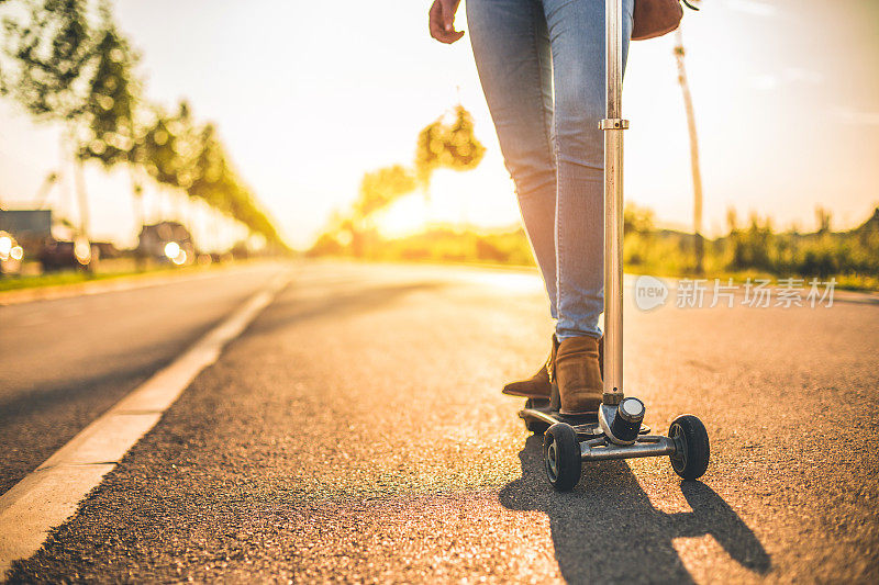 女人在自行车道上骑推滑板车的特写