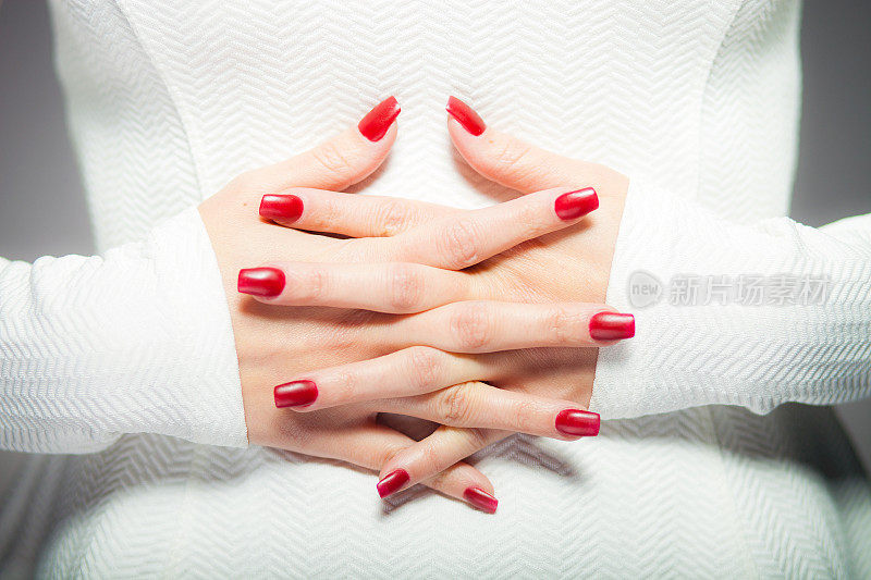 两只交叉的手，红指甲