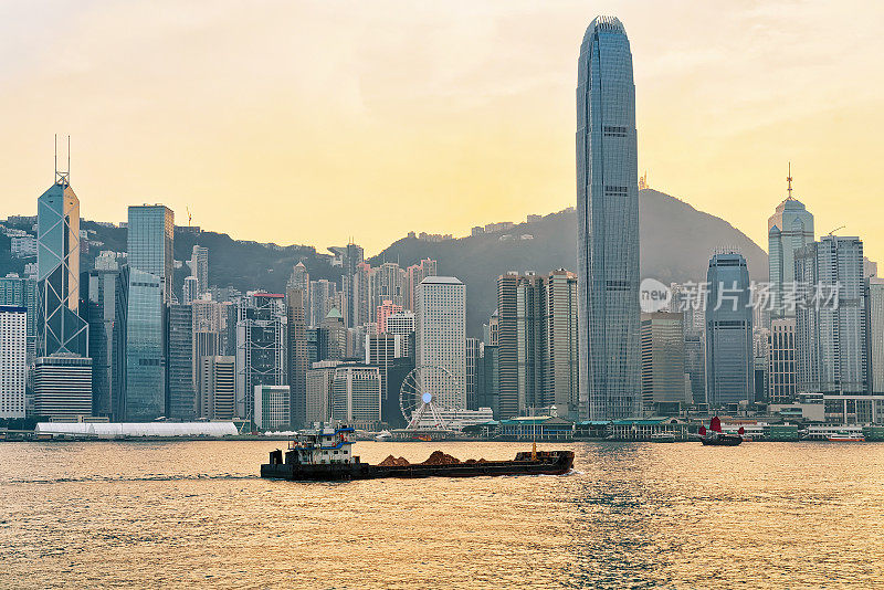 日落时，香港维多利亚港的干货船