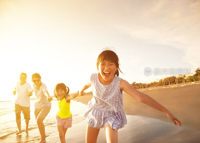快乐的家庭在沙滩上奔跑