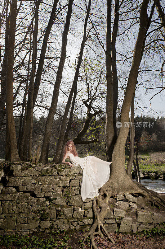 在森林里穿着白色裙子的年轻女子