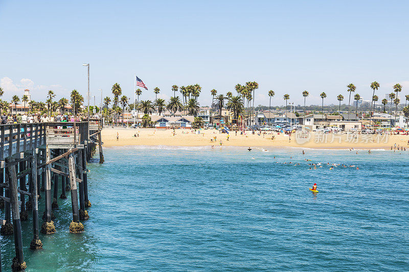 人们在享受加州新港海滩的沙滩和码头