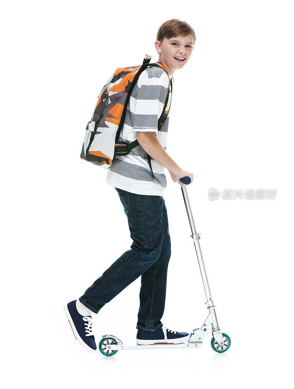 微笑的小学生骑着推滑板车