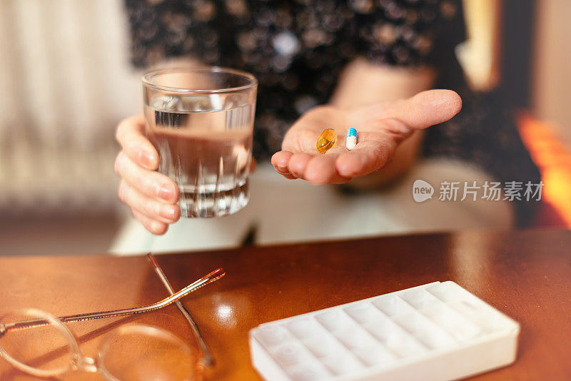 老年妇女服用每日剂量的药片和药物