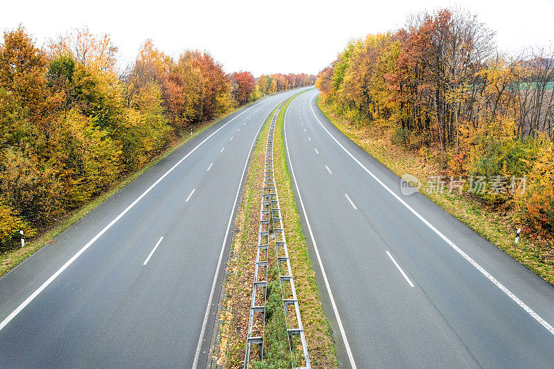 秋天，两条车道的高速公路被树木环绕