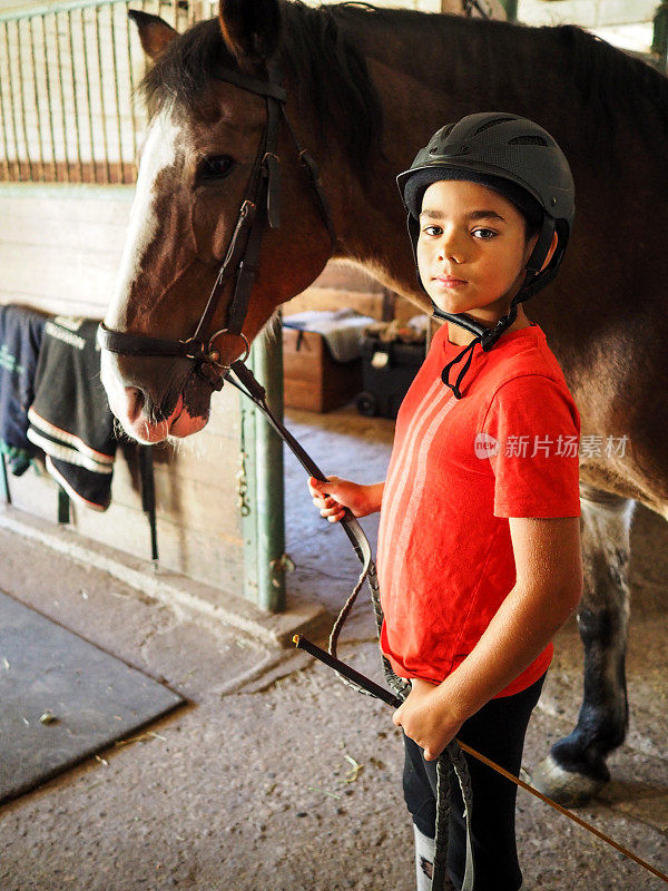 男孩和他的马在马厩里