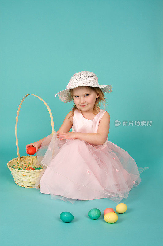 可爱的复活节女孩与帽子篮子和鸡蛋