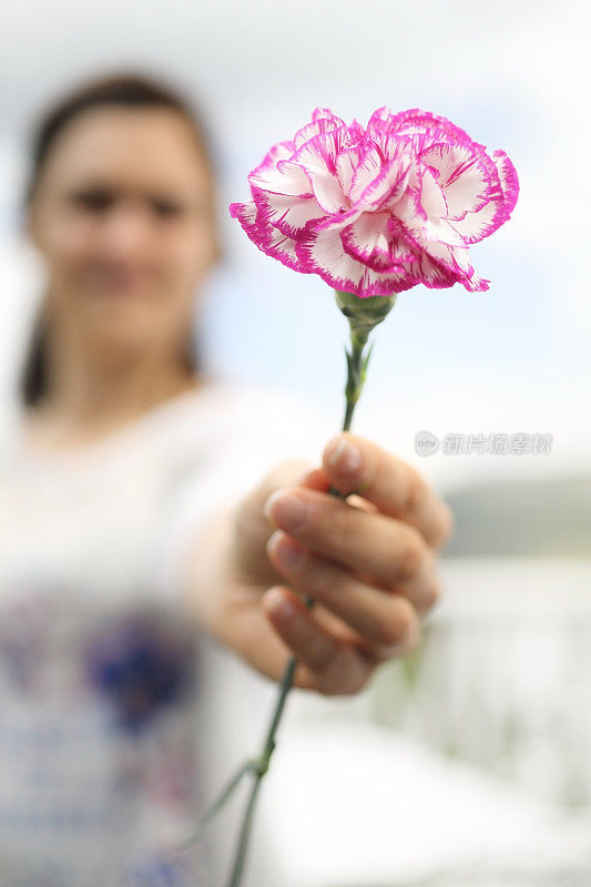 年轻女子献上粉红色的花