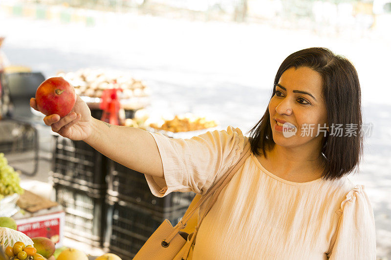 在农贸市场买水果的女人