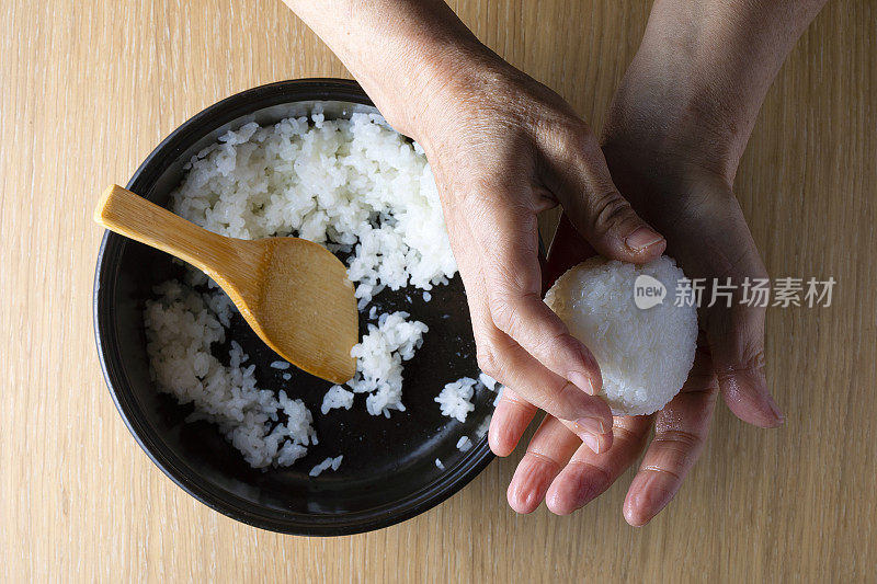 日本老妇人捧着饭团煮米饭