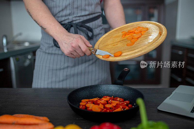 男人在厨房的桌子上切新鲜的春天蔬菜，特写。准备家庭食物，家庭厨房内部。