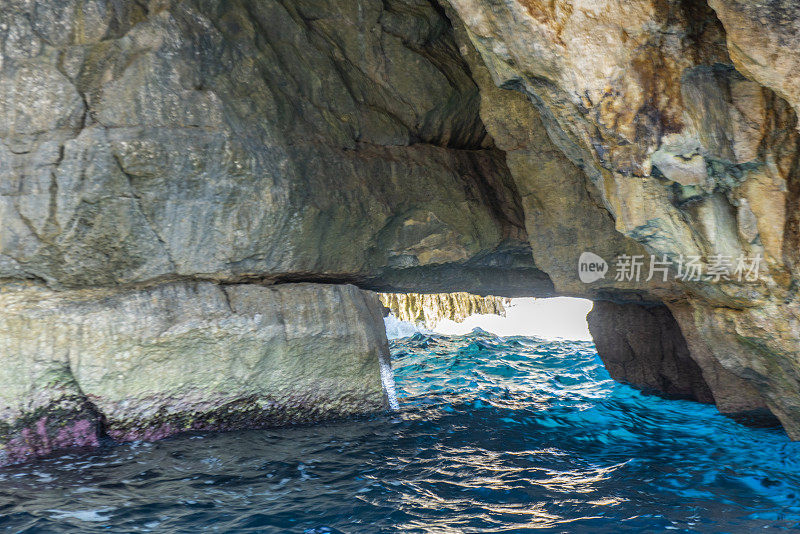 在地中海马耳他的海岸线上的蓝色洞穴旁边的海洞和岩层的观点。