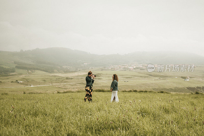 一个女人在给另一个女人拍照