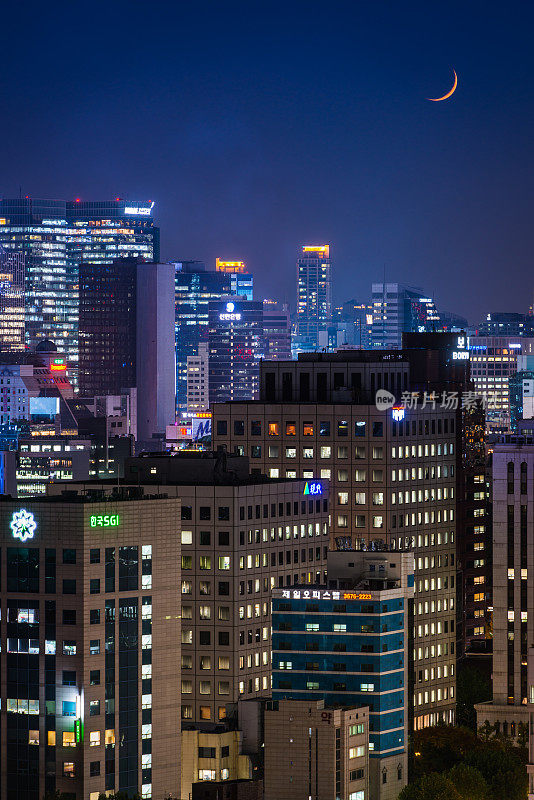 首尔新月夜空之上霓虹摩天大楼的韩国城市景观